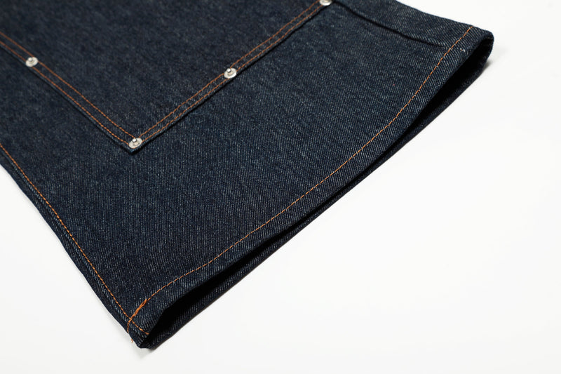 Close-up of a jean hem in deep indigo denim with orange topstitching