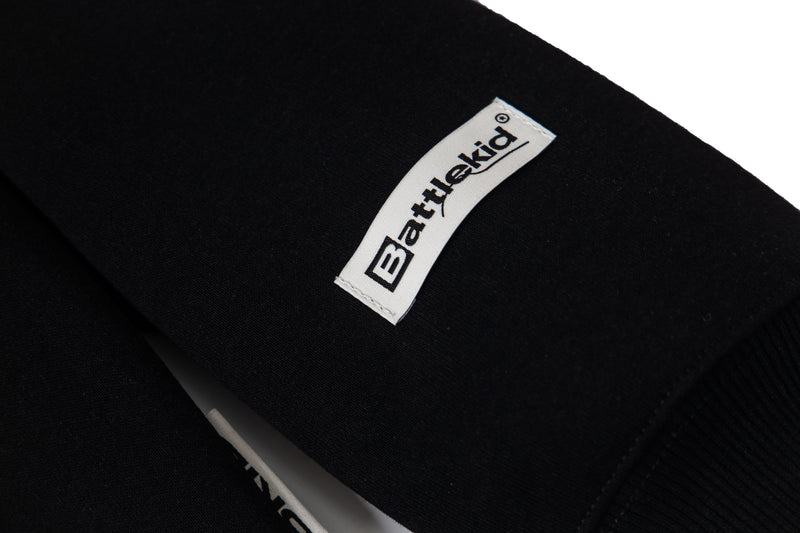 Close-up of black fabric tag reading Batterykid on the sleeve