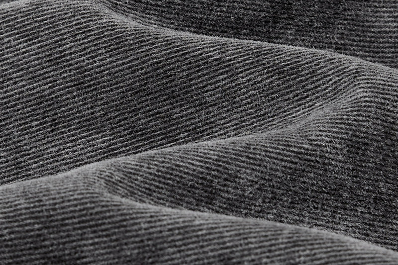 Close-up of gray-black fabric texture with diagonal weave and soft folds