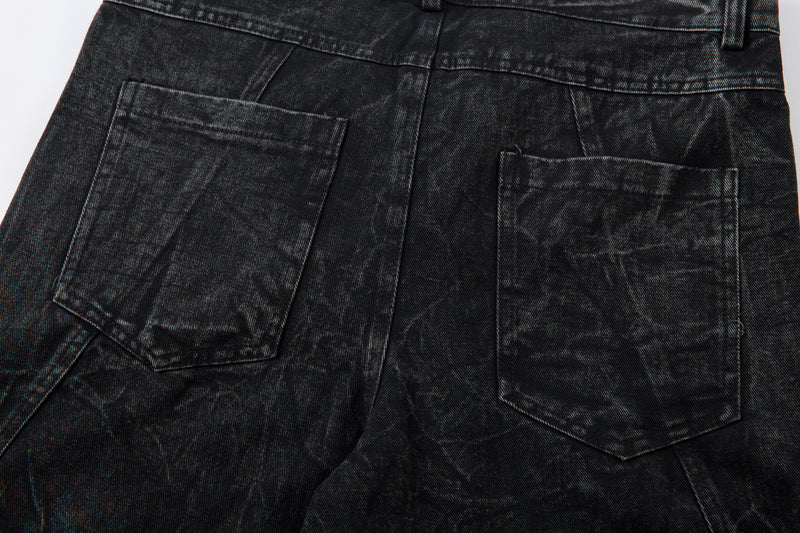 Close-up of back pockets on black oversized denim jeans