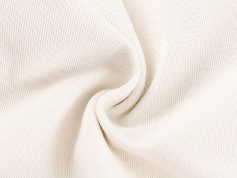 Cream ribbed fabric texture in a twisted close-up