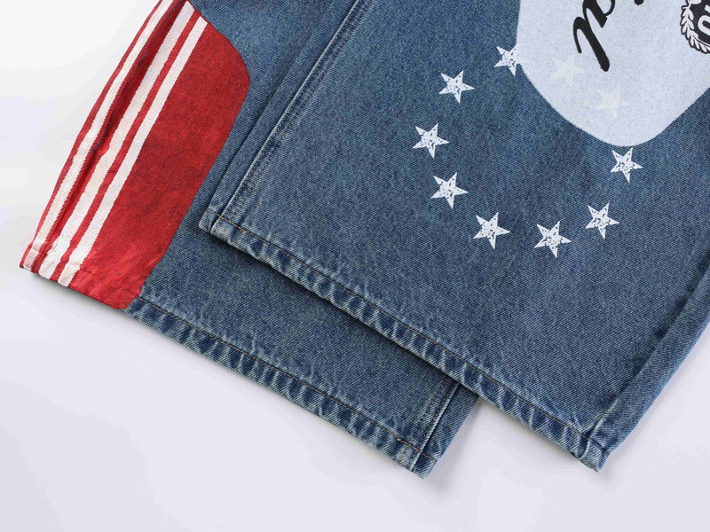 Close-up of blue denim hem with red panel, white stripes, and star print