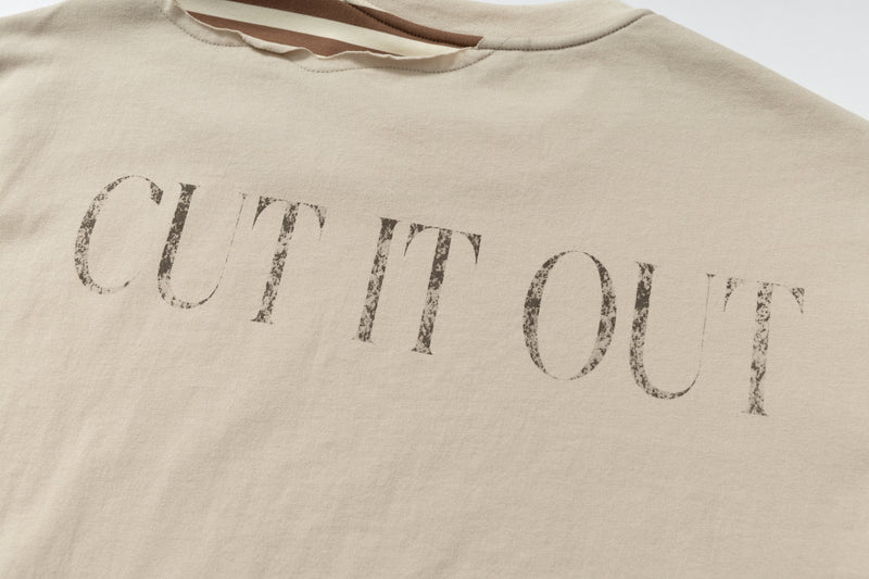 Beige layered streetwear tee with distressed No Comment graphic print across the chest