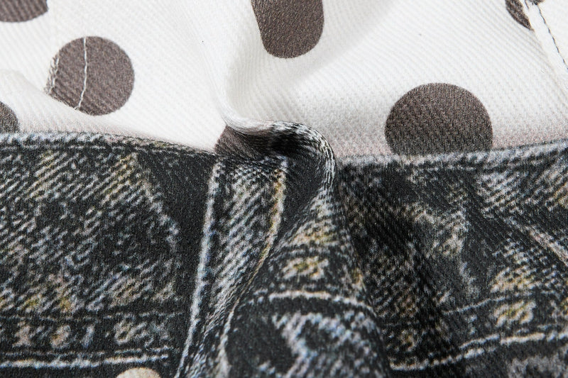 Close-up of white fabric with large brown polka dots and dark denim below
