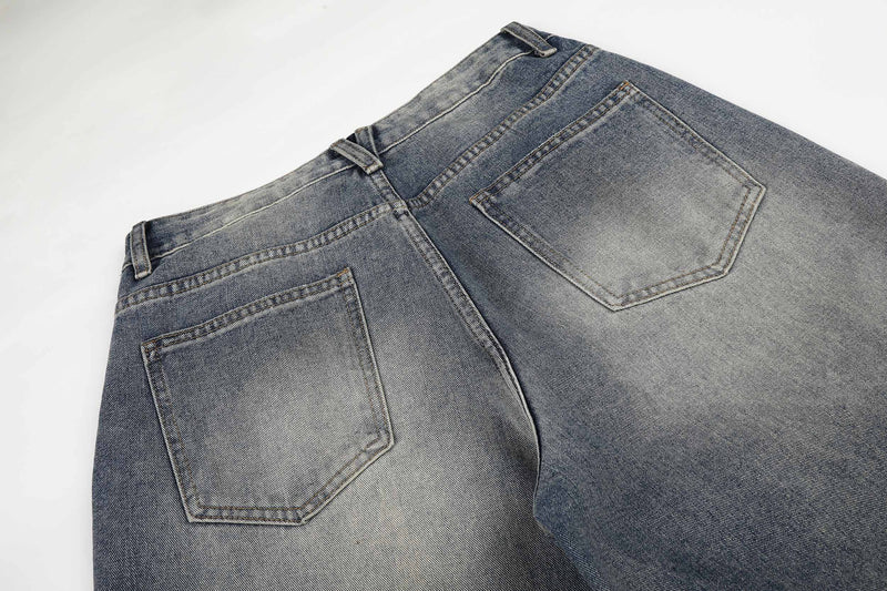 Close-up of back waistband and patch pockets on faded denim jeans