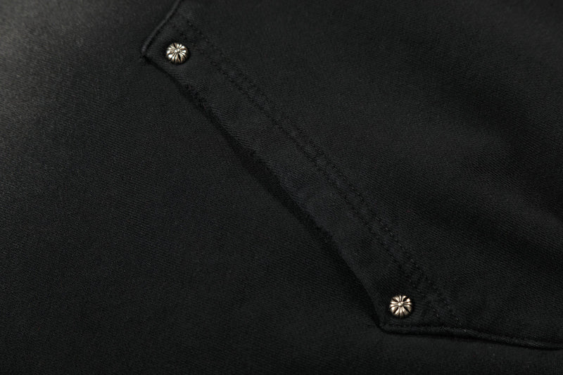 Close-up of black hoodie fabric with stitched seam and metal snap buttons