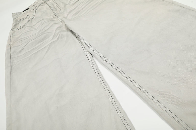 Close-up of upper leg area on light gray jeans with contrast seam lines