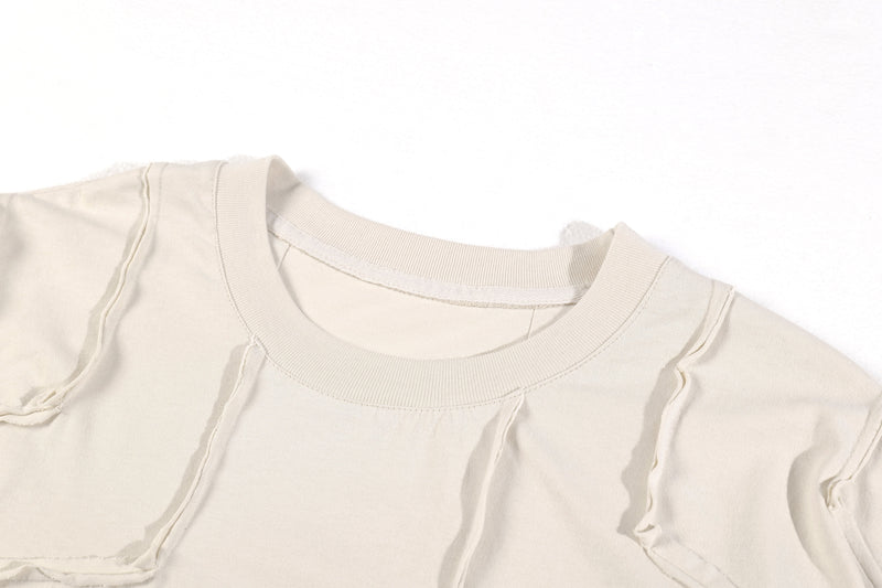 Close-up of cream ribbed crew neckline and shoulder seam on long sleeve tee