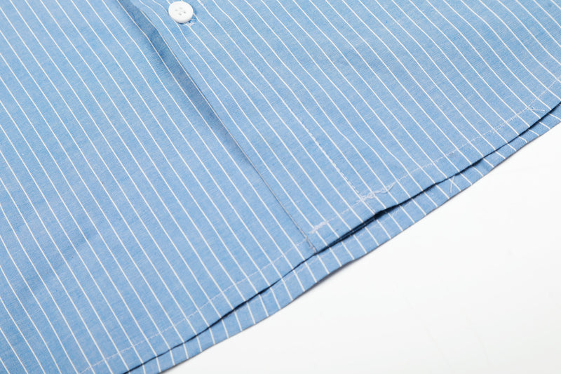 Close-up of blue striped shirt hem with side seam stitching