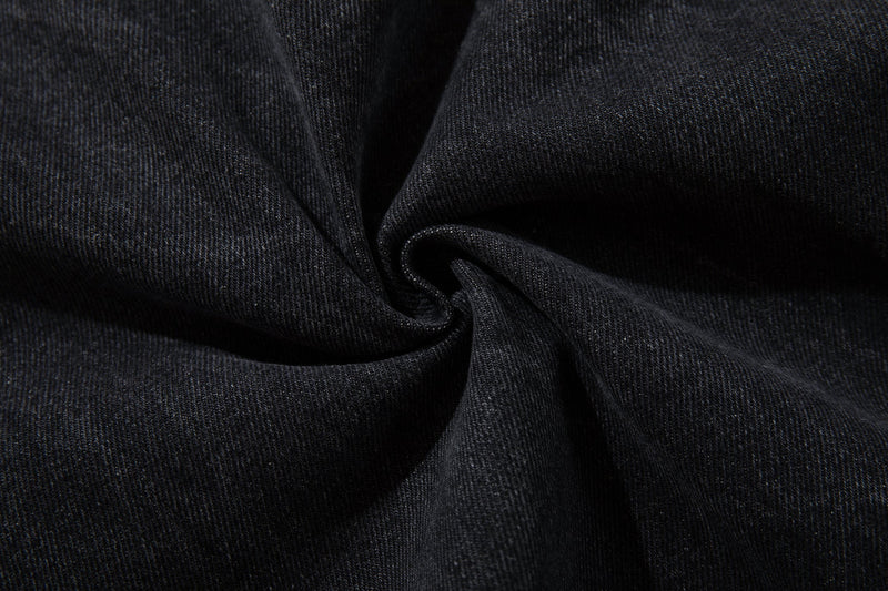 Close-up of black denim fabric with a soft folded texture