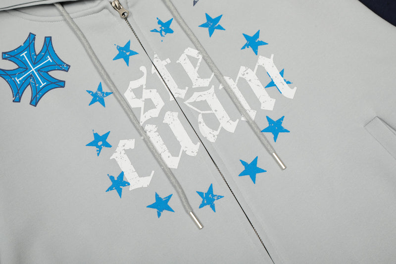 Close-up of hoodie front showing star graphics, drawstrings, and central zipper
