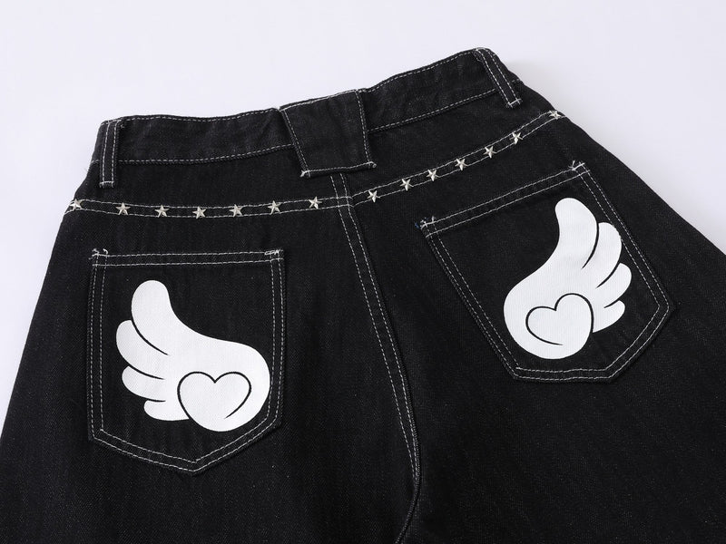 Back waist view of black denim jeans with wing pocket graphics and star-studded yoke
