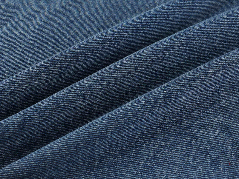 Close-up of blue denim fabric texture with diagonal folds