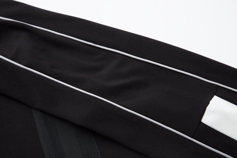 Black sleeve close-up with white piping and mesh side panel