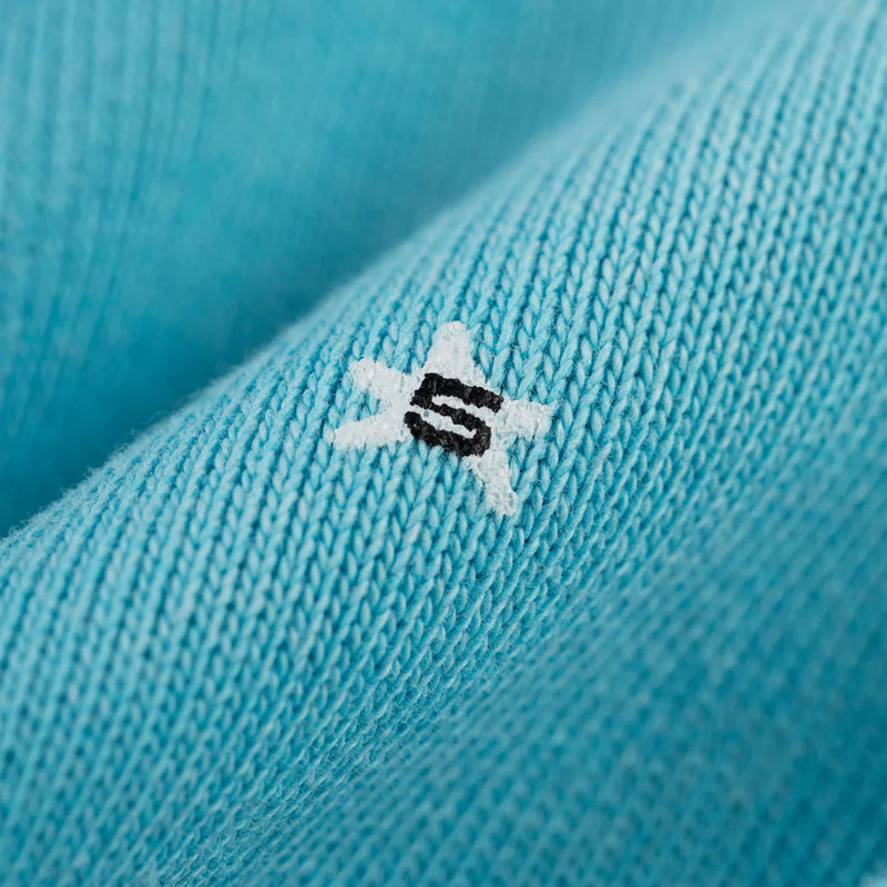 Close-up of the Turquoise Graphic Hoodie with Star Detail, showing a small white star with a black "S" embroidered at the center, capturing its comfort fit and signature style.