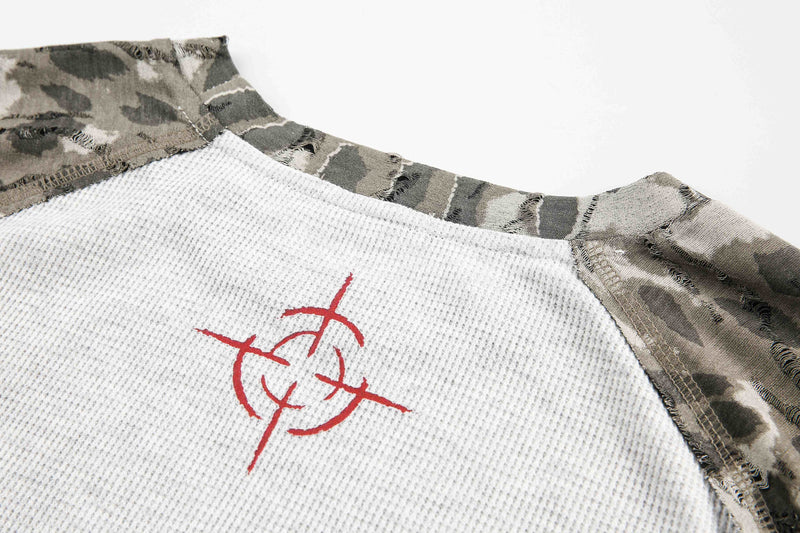 Close-up of red graphic print on white waffle-knit chest panel with camouflage trim