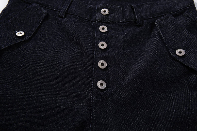 Close-up of the front button fly and waistband on dark indigo denim pants