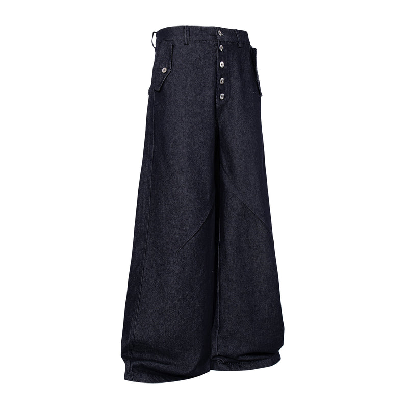 Angled front view of dark indigo wide leg denim pants with side flap pockets and button fly