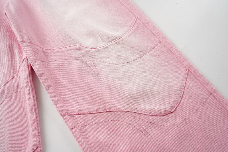 Close-up of pink washed denim side leg panel with curved stitched seams
