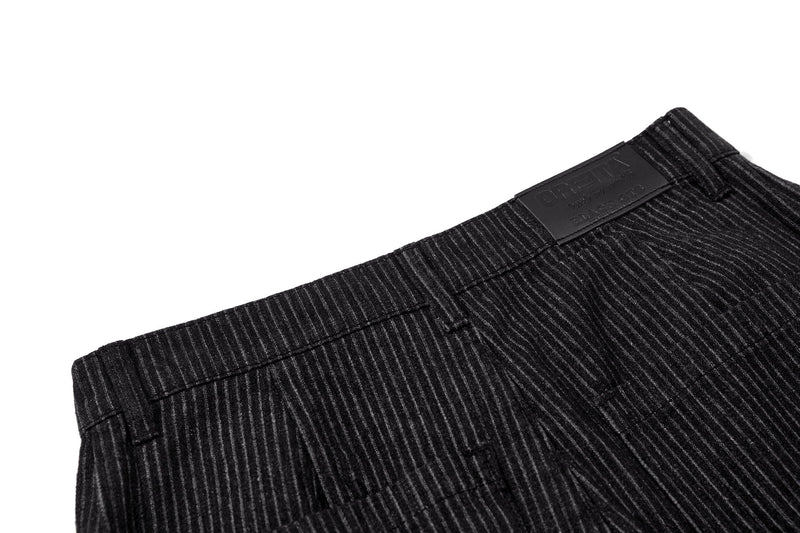 Close-up of back waistband on black pinstripe trousers with brand label