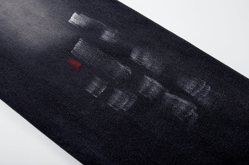 Leg close-up with white and red brushstroke marks on dark wash jeans