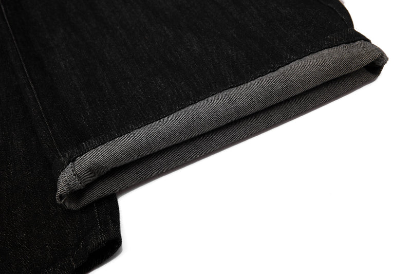 Close-up of rolled hem on black wide-leg denim pants