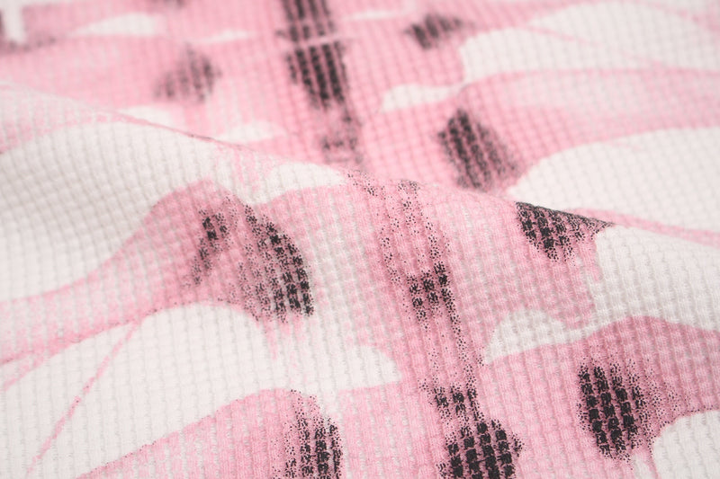Close-up of pink and white ribbed tee fabric with distressed black skeleton graphic print and grunge texture