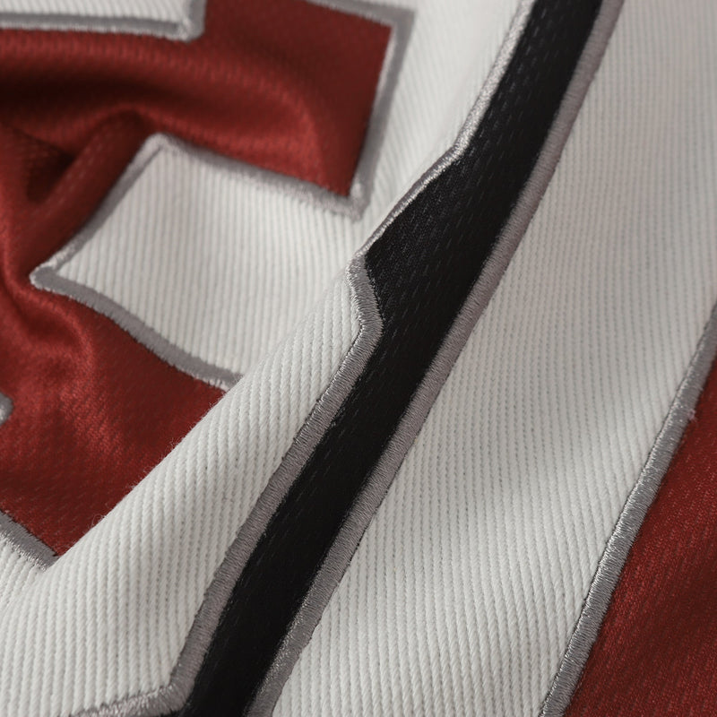Close-up of a red and white retro soccer jersey tee with a bold black number 30 and silver-trimmed stripes