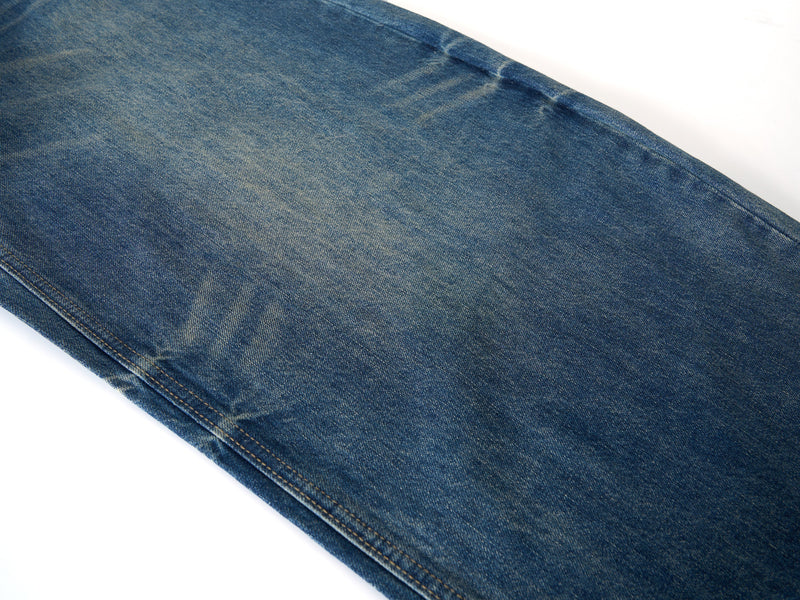 Close-up of denim leg with light vintage wash and subtle faded streaks