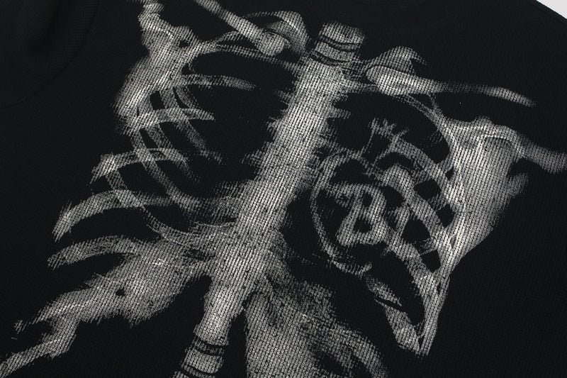Black streetwear tee with oversized white ribcage skeleton graphic print across the chest
