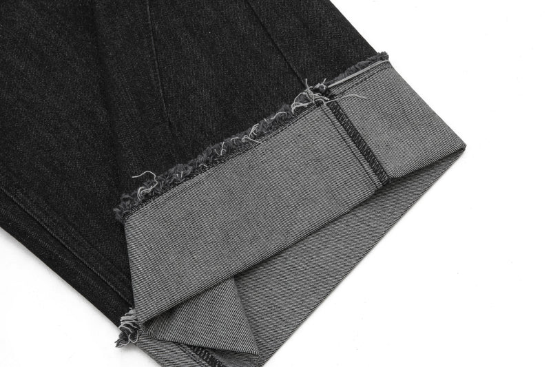 Close-up of black denim shorts cuffed hem with layered gray cuff and frayed stitching