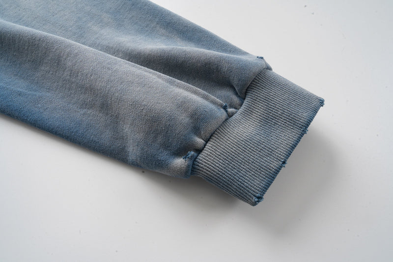 Close-up of ribbed sleeve cuff on faded blue hoodie