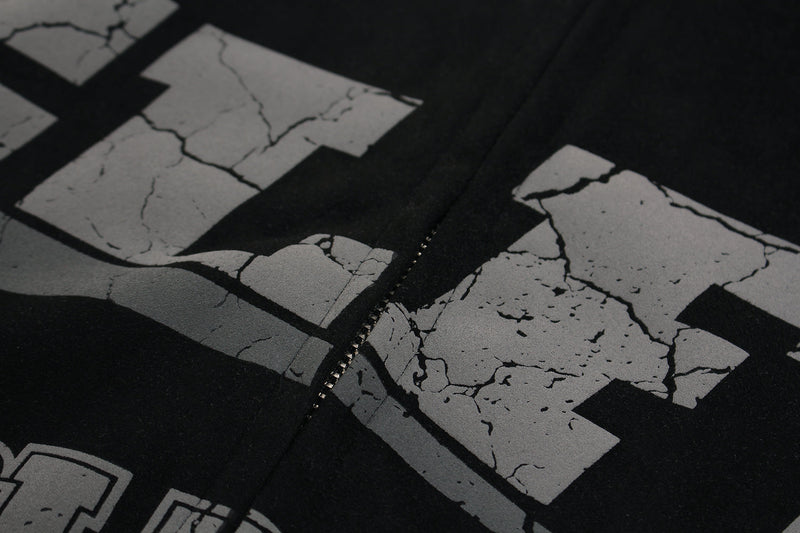 Close-up of cracked GLFS lettering around the center zipper on black hoodie
