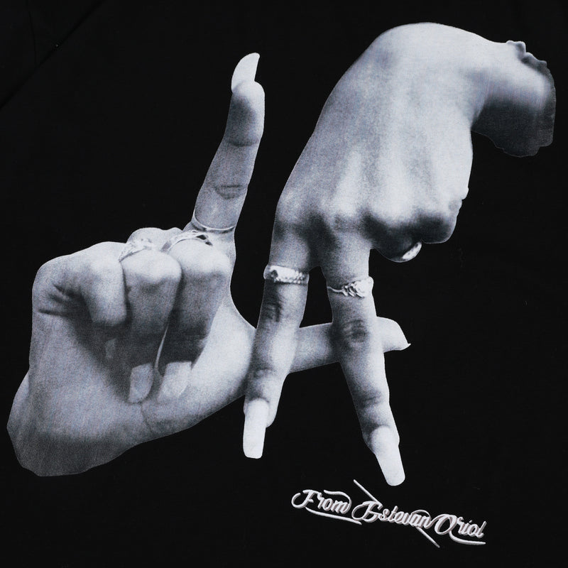 Black oversized tee with a monochrome hand graphic and From Estevan Oriol script on the front