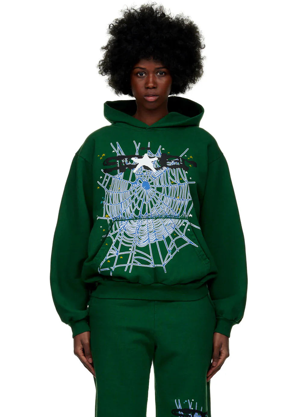 A person with a natural afro hairstyle wears the Dark Green Graphic Hoodie with Spider Web Print – Comfort Fit Pullover Hoodie for Everyday Wear, featuring a large white spiderweb, a spider, and colorful accents on the front.