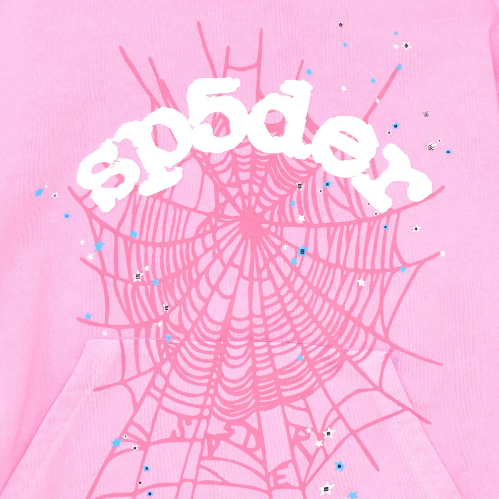 The Pink Graphic Hoodie with Spider Web Print – Comfort Fit Pullover features a white graffiti-style sp5der logo, a bold pink web graphic, and blue and silver star sequins—making it a standout streetwear pullover.