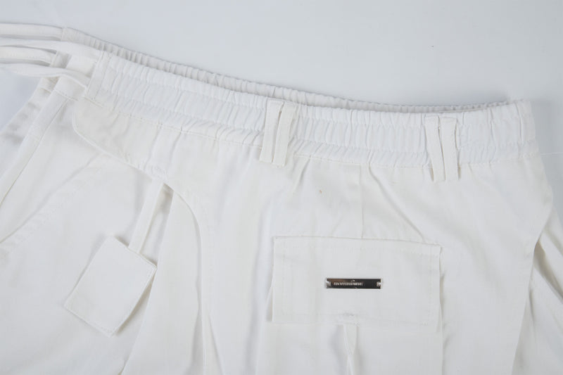 Close-up of white cargo pants front pockets and waistband detail