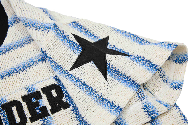 Close-up of a cream and blue striped knit tee with a black star and bold varsity lettering details