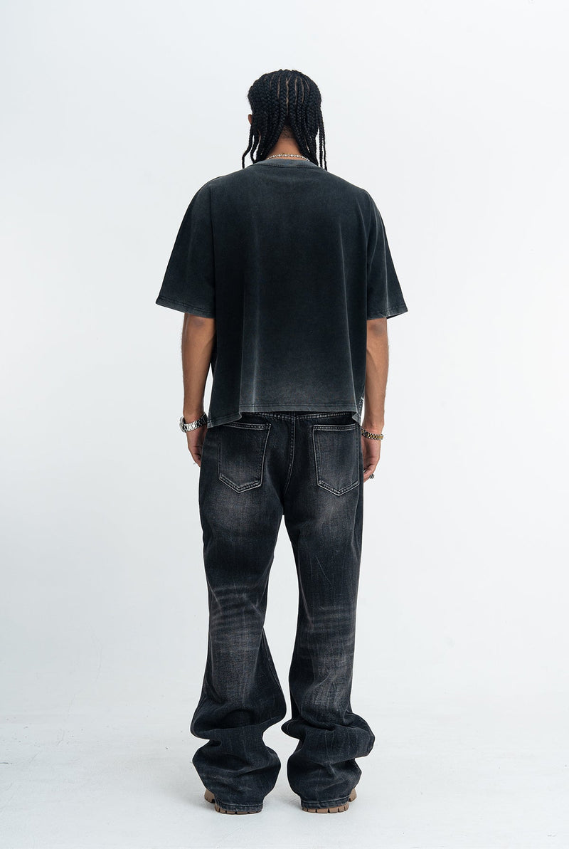 Vintage washed black oversized graphic tee shown from the back with faded wash and relaxed fit