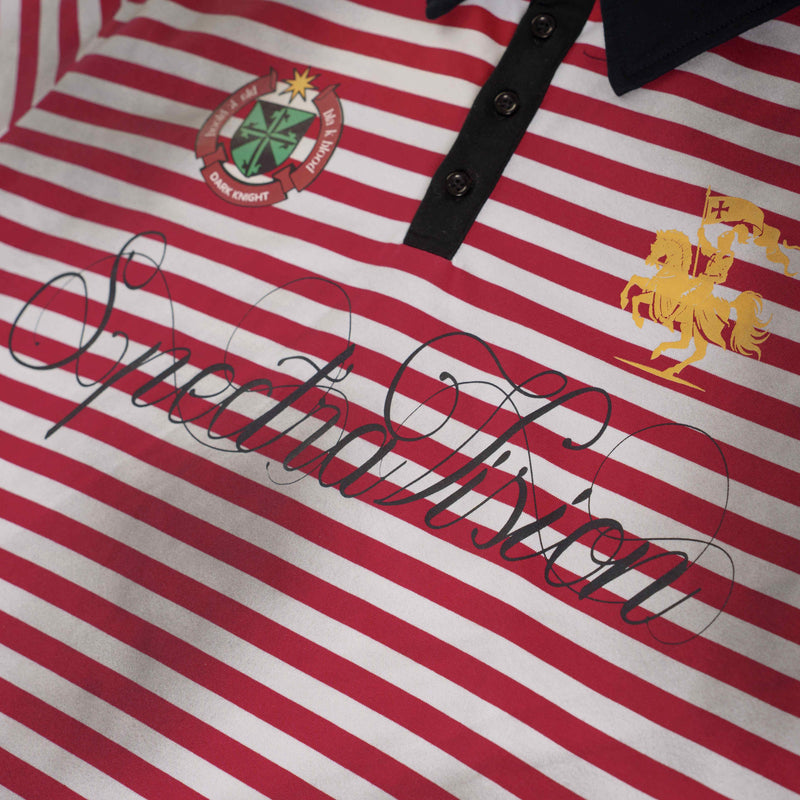 Close-up of a red and white striped polo tee with black button placket, crest patch, and ornate script graphic across the chest
