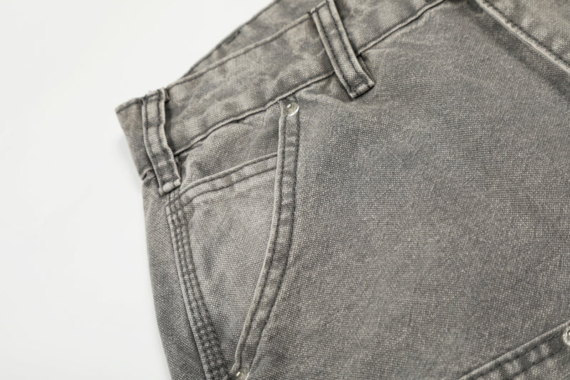 Close-up of gray carpenter jeans back pocket and waistband stitching