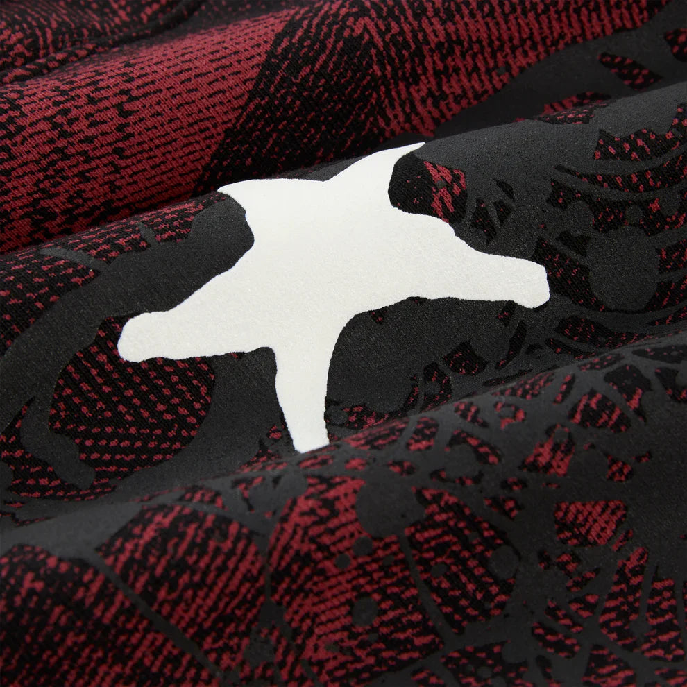 Close-up of the Red and Black Graphic Hoodie with Star Detail and Spider Web Print, showing its textured abstract pattern and central white star shape. Soft folds highlight the comfort fit of this stylish streetwear pullover hoodie.