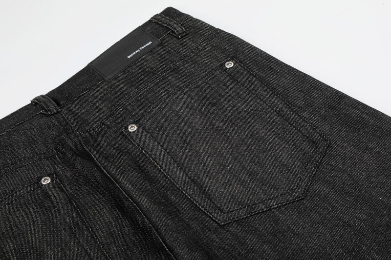 Close-up back view of black denim rear pocket and waistband label