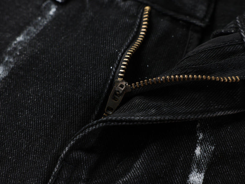 Close-up of gold zipper in black denim fabric