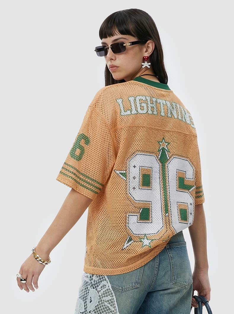 Tan mesh streetwear jersey with LIGHTNING 96 graphic and oversized fit, styled on a model with sunglasses