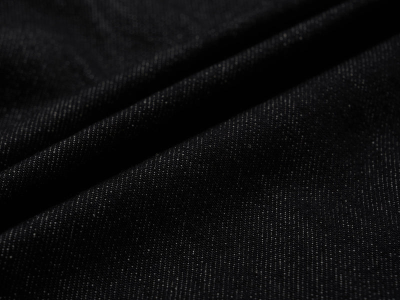 Close-up of dark wash denim fabric texture with soft folds