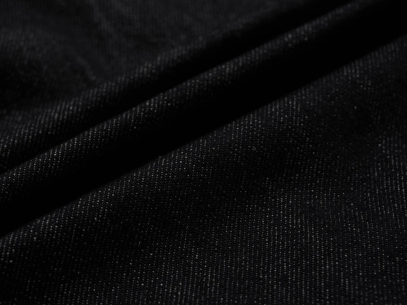 Close-up of dark wash denim fabric texture with soft folds
