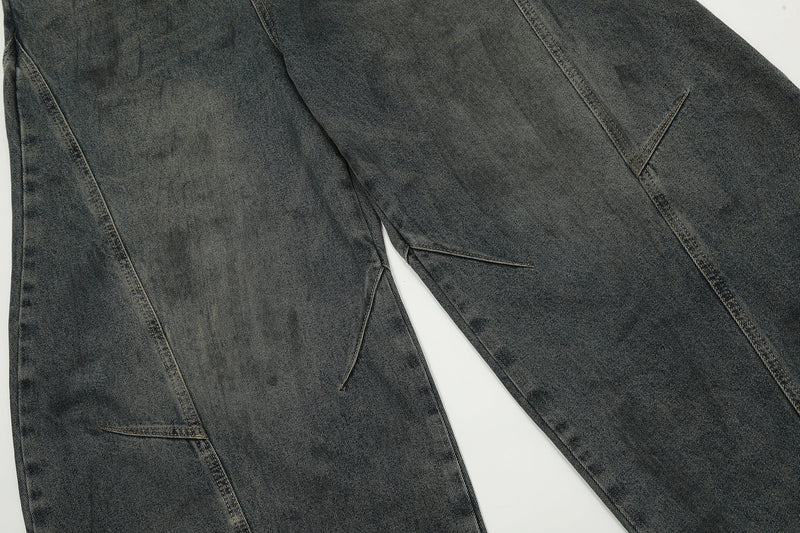 Close-up of front leg seams on dark washed balloon jeans with curved panel stitching