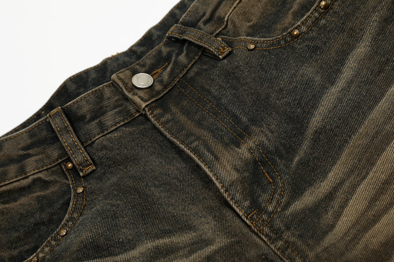 Close-up of front waistband and pocket on vintage-wash jeans with visible topstitching