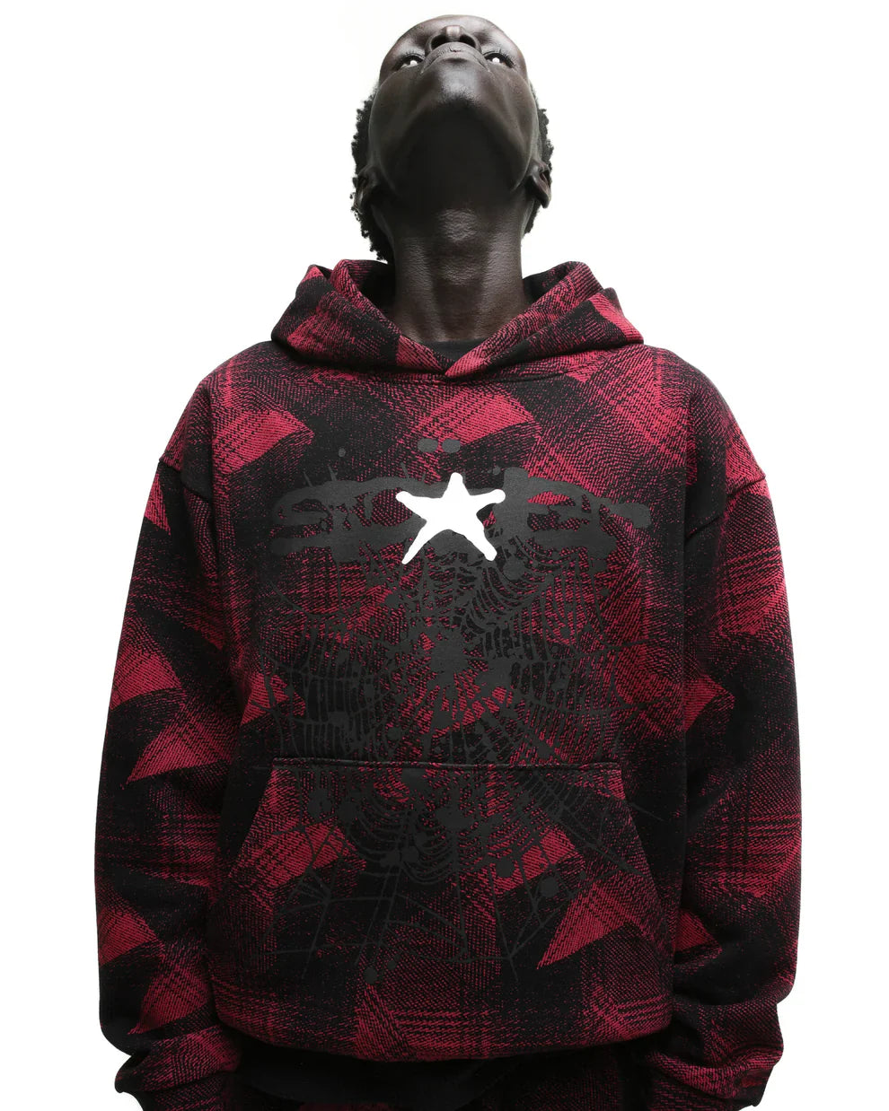 A person in the Red and Black Graphic Hoodie with Star Detail and Spider Web Print – Comfort Fit Pullover Hoodie gazes upward, head tilted back, against a plain white background.